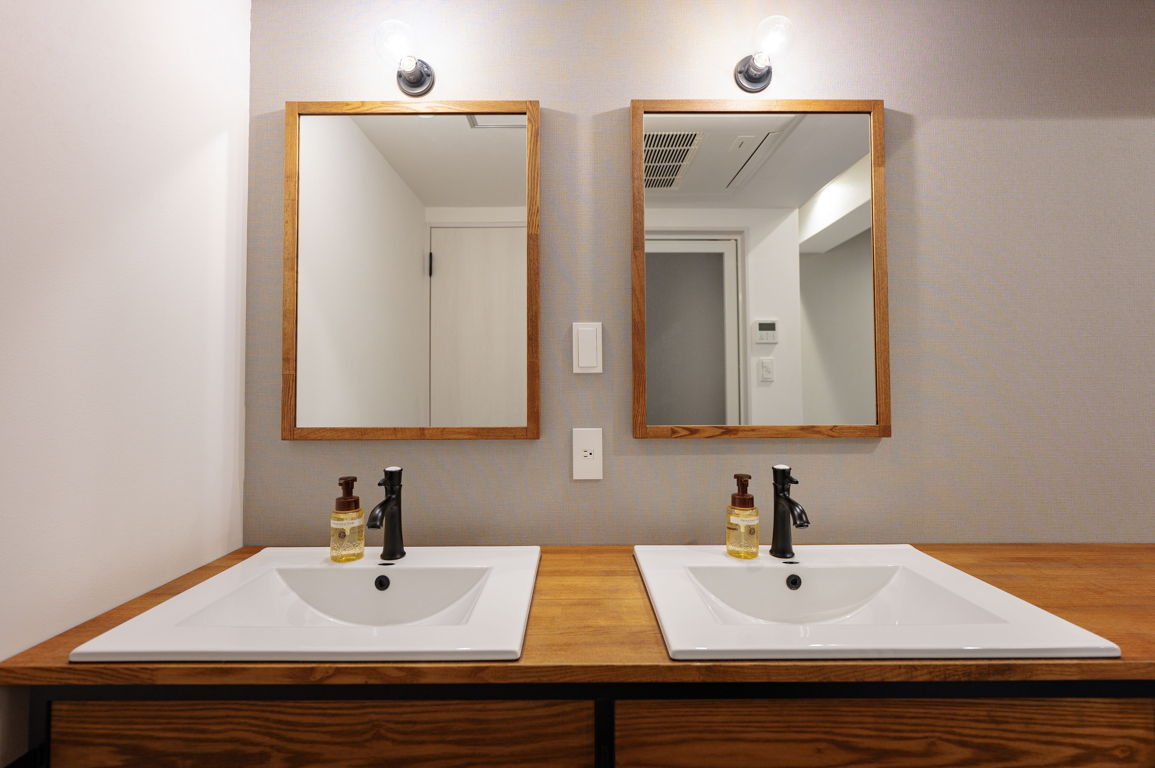A bathroom with two sinks, each with a mirror above.