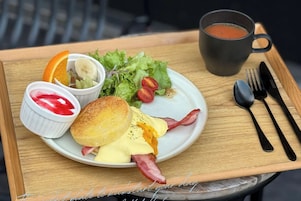 Bandeja de desayuno con huevos, tocino, tostadas y una ensalada.