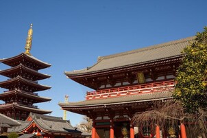 Un temple japonais traditionnel, doté de plusieurs toits de style pagode et d’une porte rouge imposante.