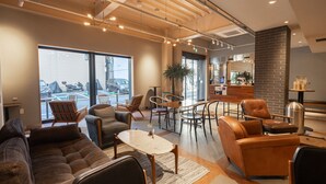 A modern hotel lobby with leather sofas, a coffee table, and a dining area. - OTHER SPACE Asakusa (Tokyo)