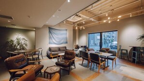 A modern interior with a large window, a sofa, a dining table, and various chairs. - OTHER SPACE Asakusa (Tokyo)