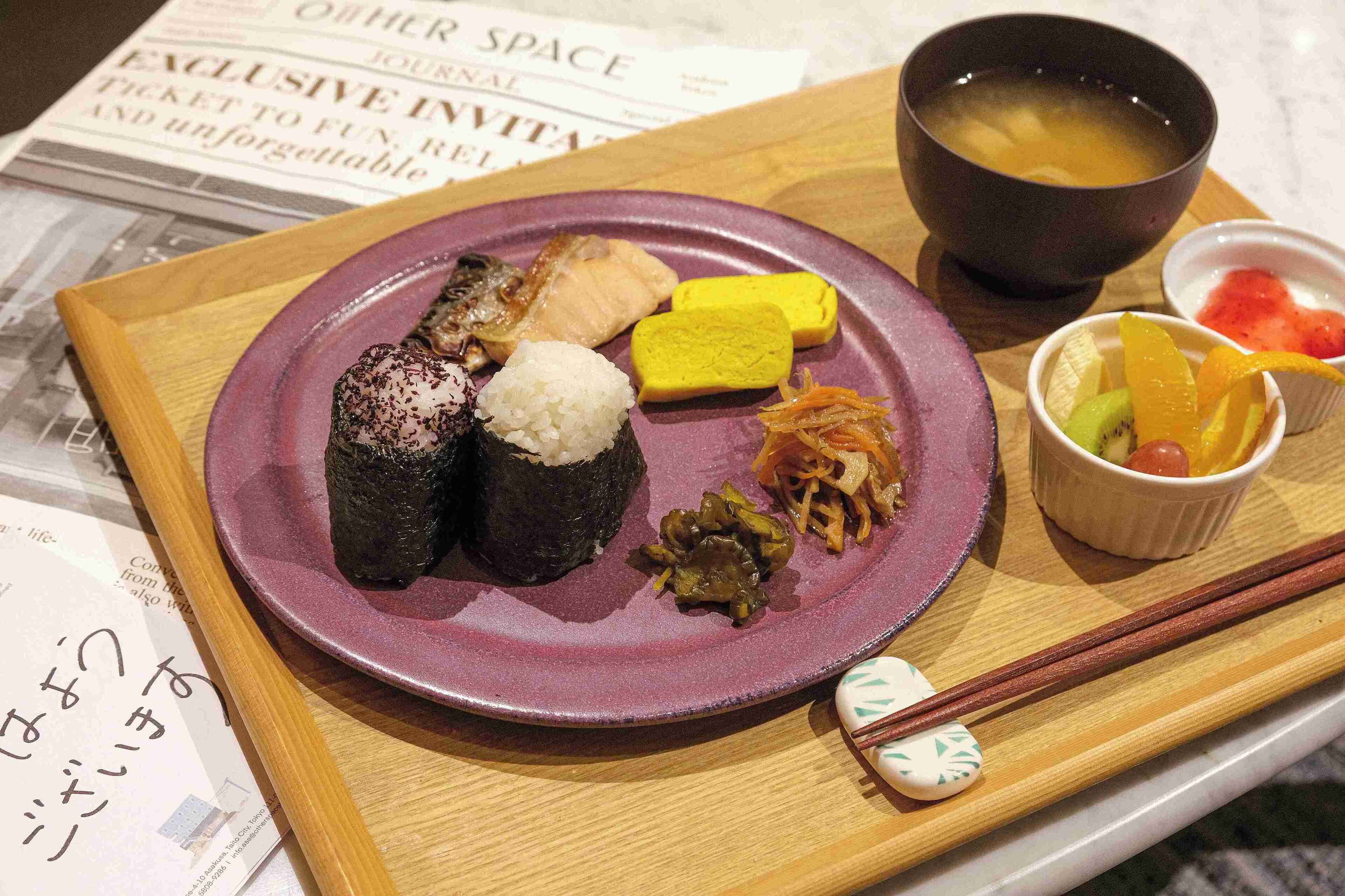 A plate of sushi, a bowl of soup, and a small dish of pickled vegetables.