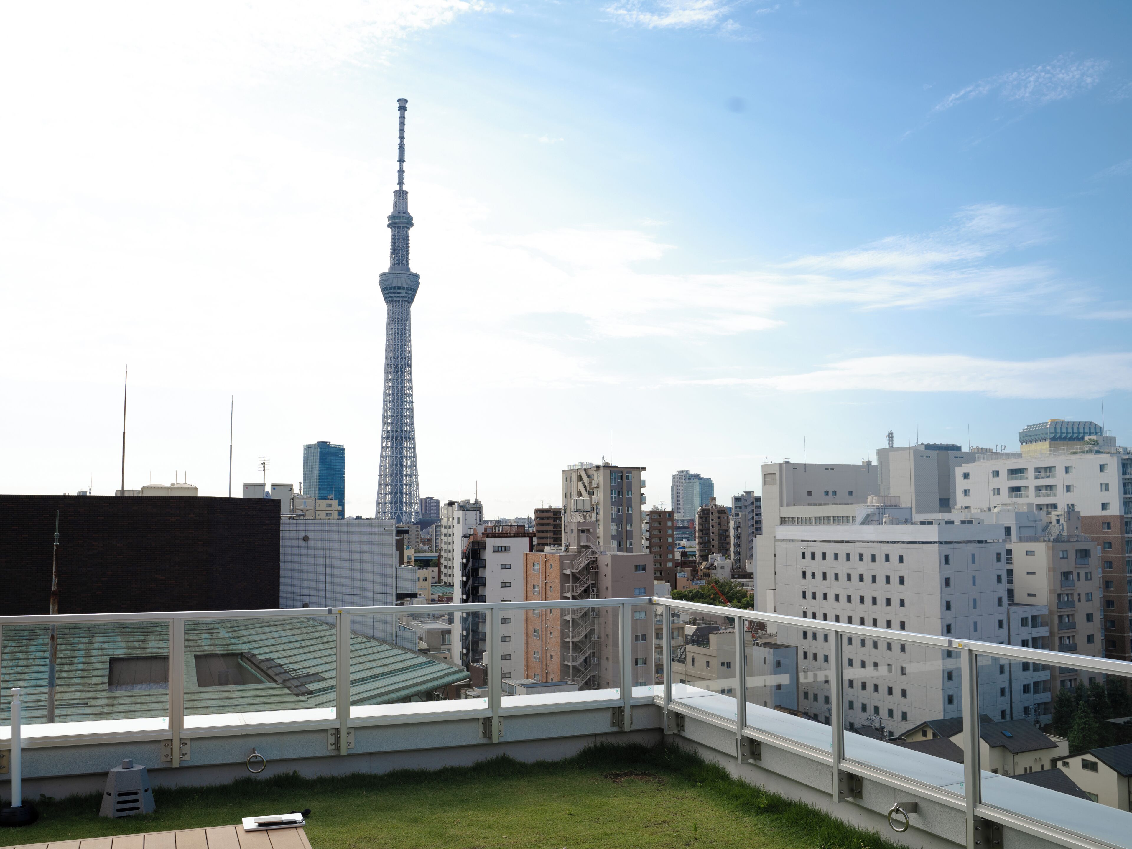 A high-rise building with a prominent tower, surrounded by other buildings and a clear sky.