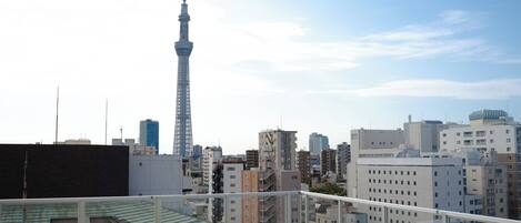A high-rise building with a prominent tower, surrounded by other buildings and a clear sky.