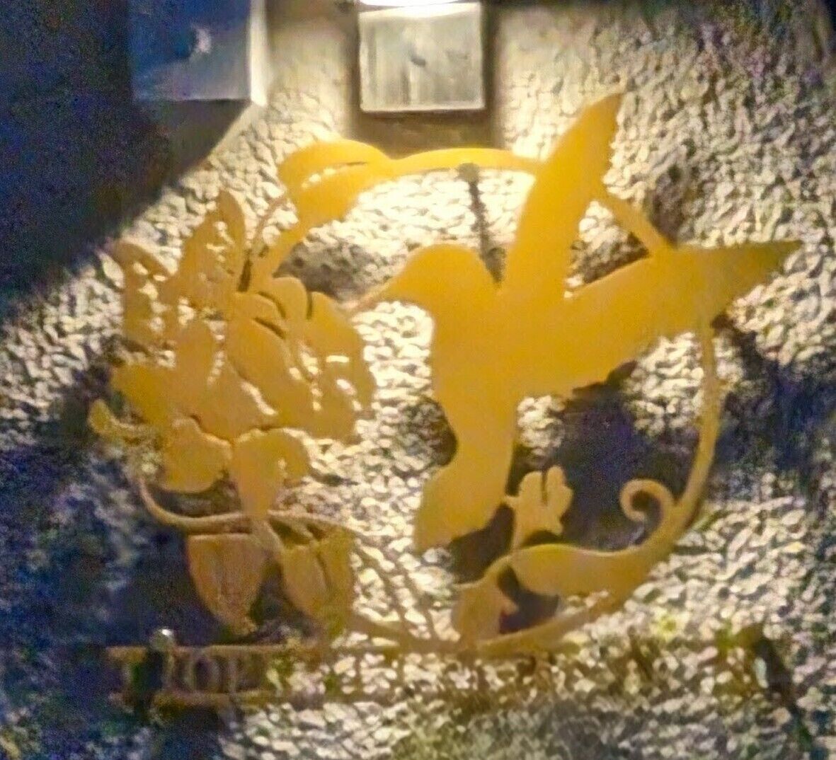 A wall with a golden bird and floral design.