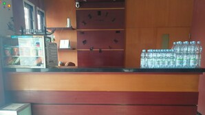 A reception area with a counter, a water dispenser, and a clock on the wall. - Hotel O Kost Orange Syariah (Makassar)