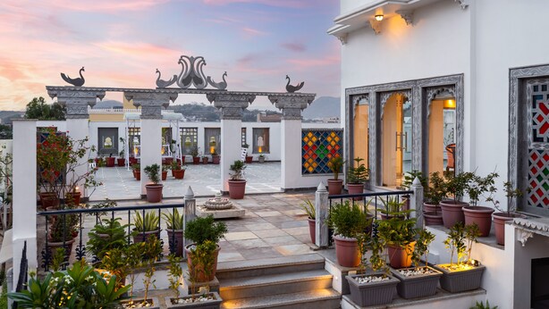 A courtyard with potted plants, a staircase, and traditional architectural elements. - Maan Vilas By Stone Wood Udaipur (Udaipur)