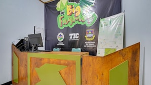Una mesa de recepción con un gran cartel de fondo, una computadora y un mapa en la pared.