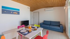 A dining area with a table, chairs, and a blue sofa. - Splendid attic with large veranda. (RAGUSA)