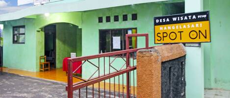 A green building with a sign reading "DESA WISATA NANGELASARI SPOT ON".
