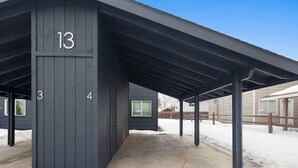 Ein überdachter Außenbereich mit Betonboden, nummerierten Abschnitten 3, 4 und 13 sowie einem strahlend blauen Himmel im Hintergrund.