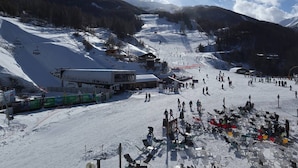 A ski resort with a chairlift, ski slopes, and a snow-covered landscape.
