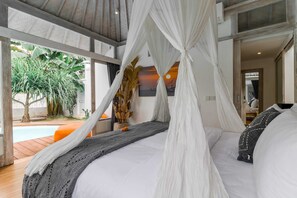 Un dormitorio con cama con dosel, vistas al exterior y un ventanal grande.