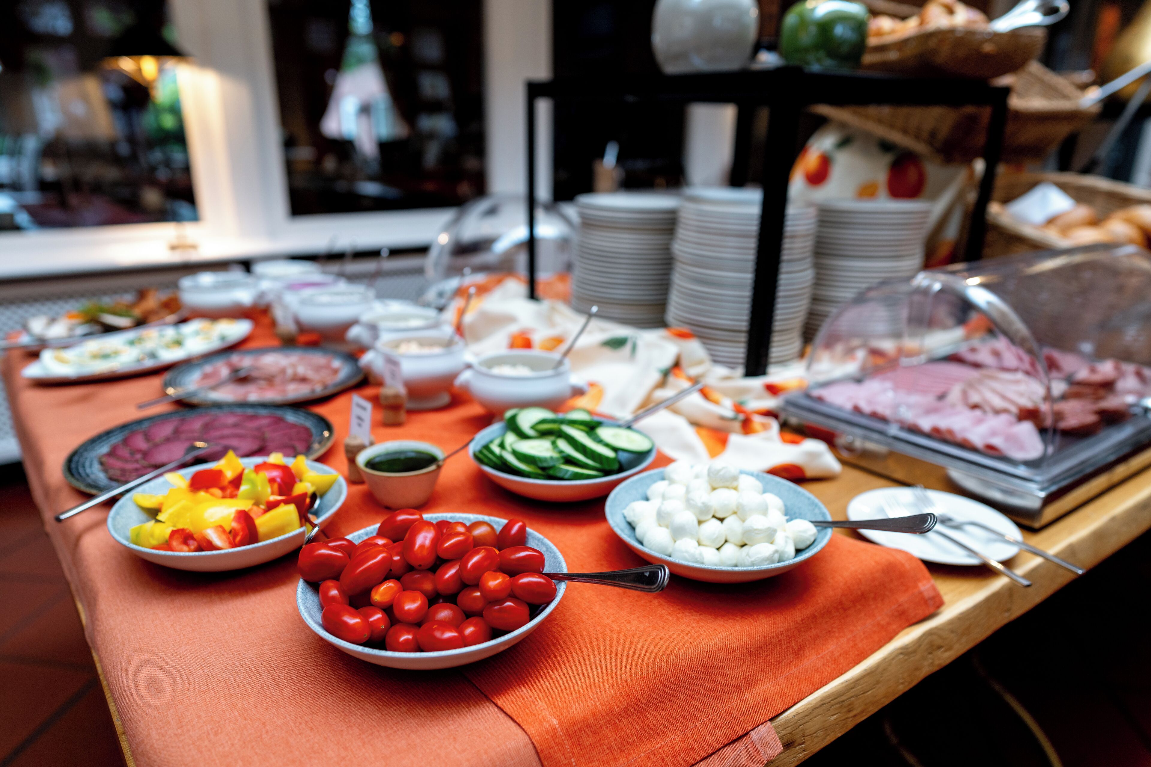 A buffet table with various dishes including fruits, vegetables, and meats.