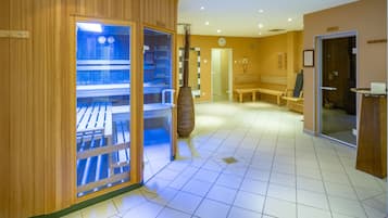A spa area with wooden walls, a glass door leading to a massage room, a bench, and a reception desk.