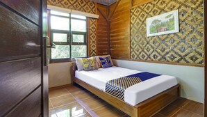 A wooden room with a bed, a window, and patterned walls. - Hotel O Desa Wisata Guranteng (Guranteng)