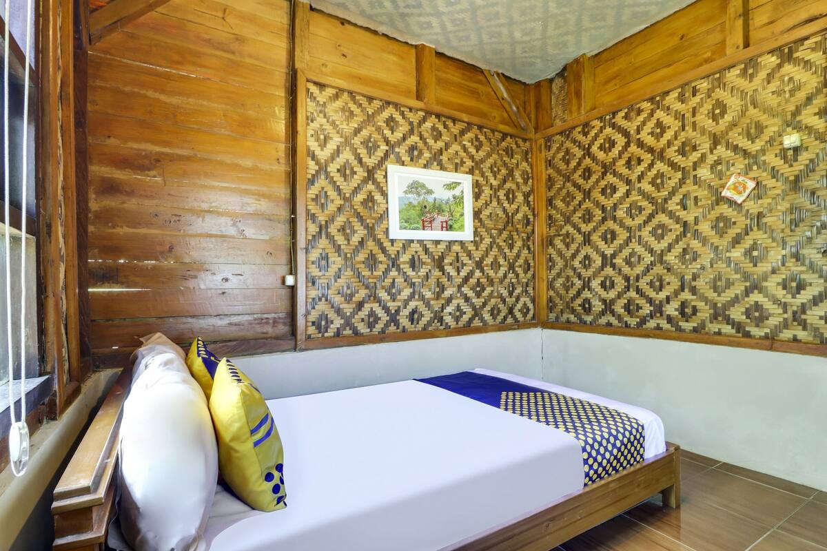 Una habitación de madera con una cama, un cuadro en la pared y un diseño decorativo en la pared.