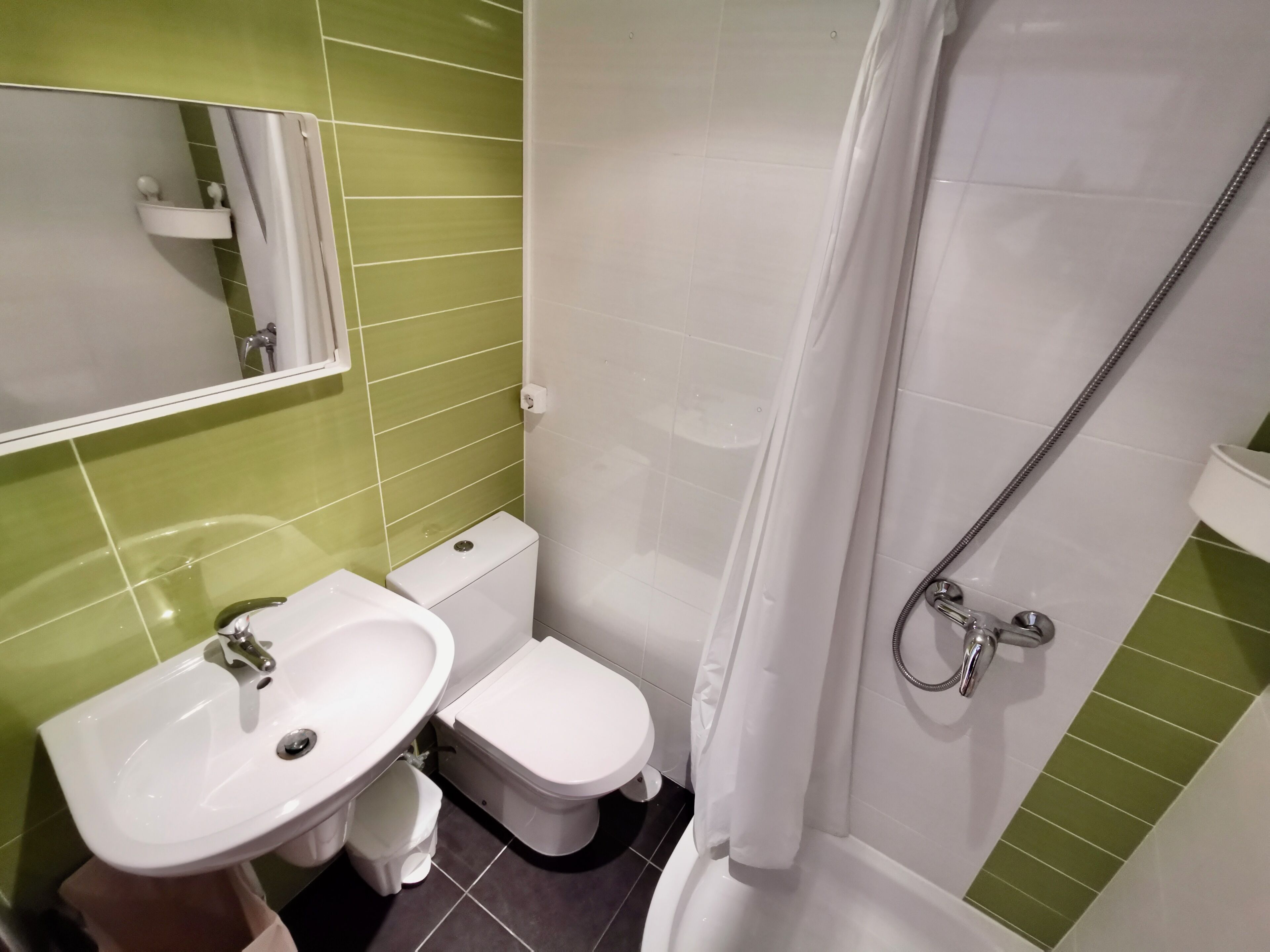 A bathroom with a sink, toilet, and shower.