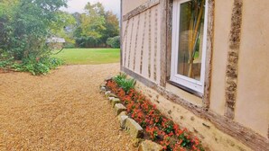 A building with a window, a gravel path, and a flower bed. - Family Retreat with Garden, Near Leisure Activities (Saint-Poix)