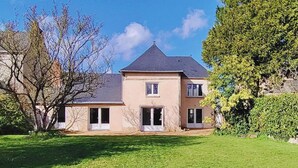 A two-story house with a dark roof, a central entrance, and a small porch. - Family Retreat with Garden, Near Leisure Activities (Saint-Poix)