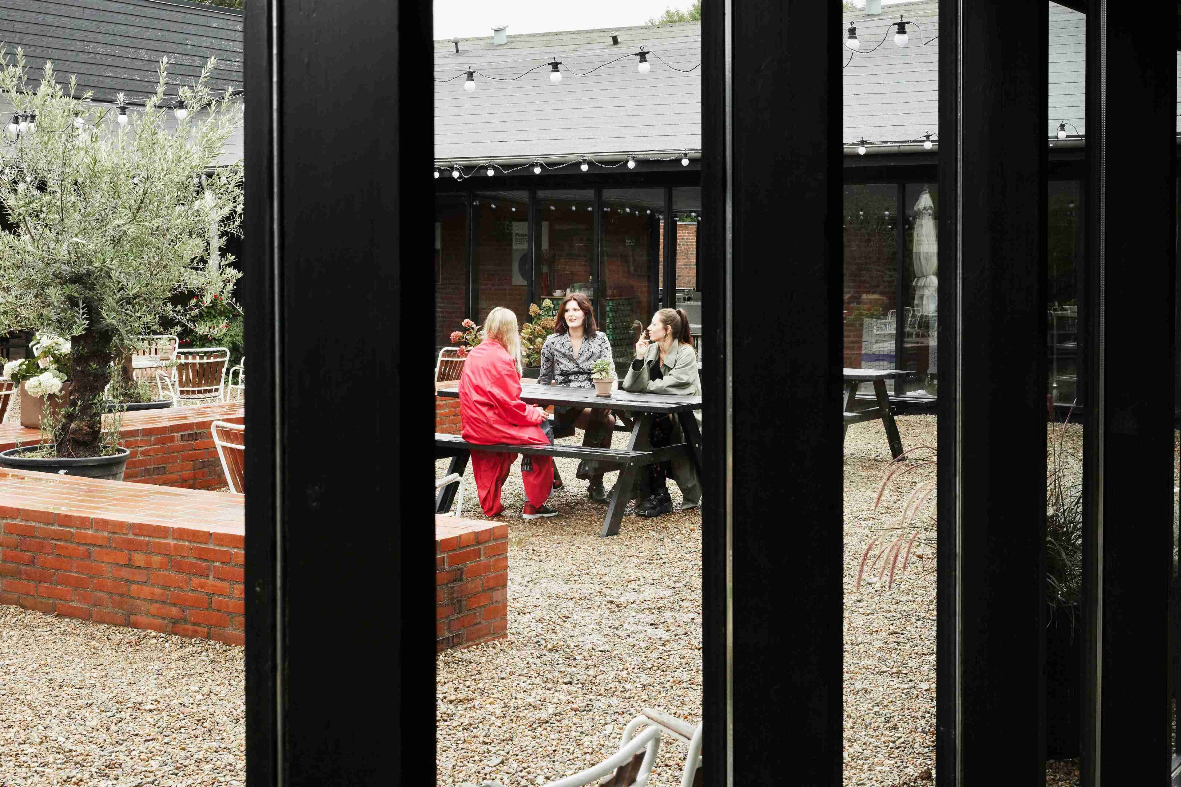 Un espace extérieur aménagé en terrasse, avec un jardin en briques, une table et des chaises.