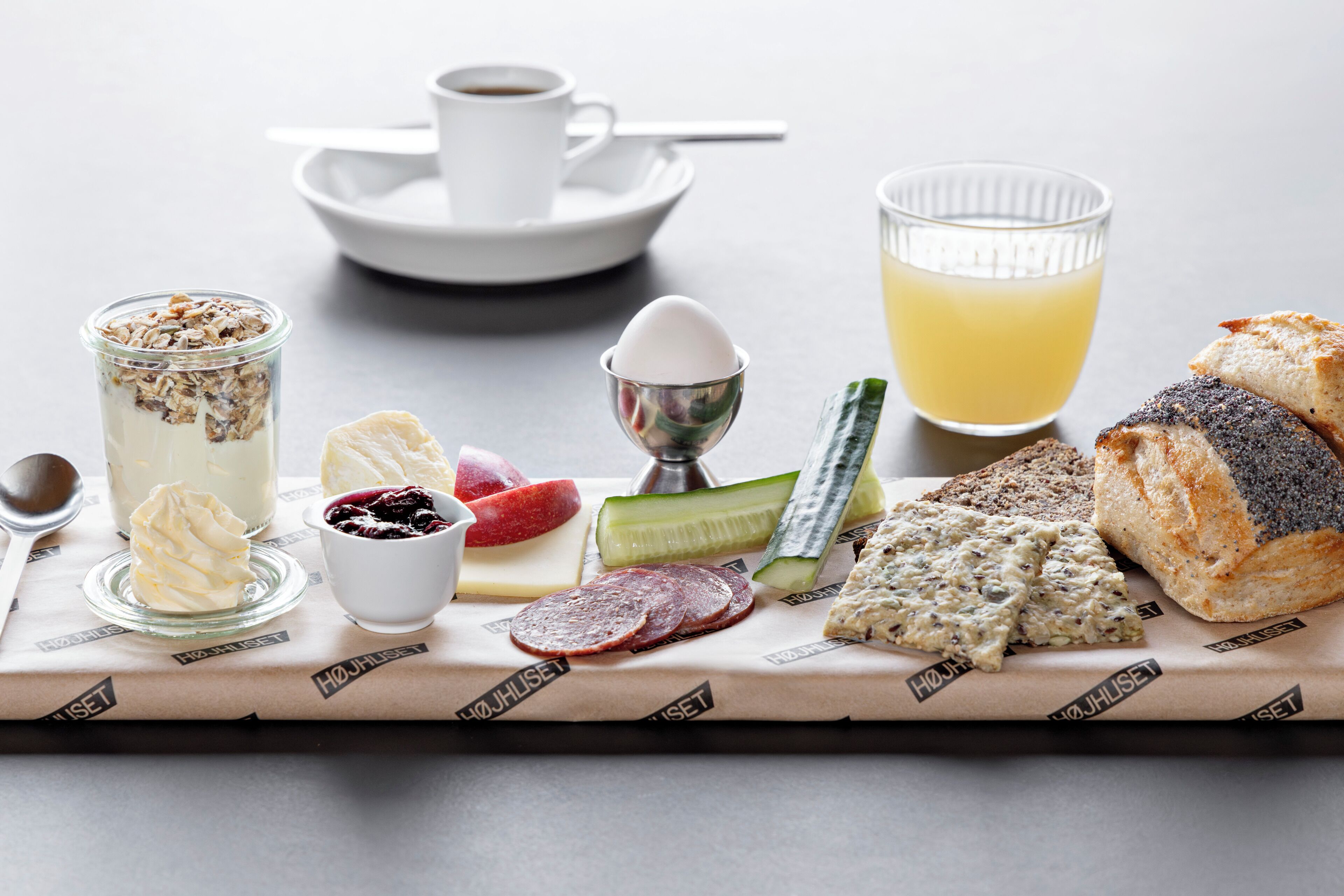 A breakfast setting with various food items and a cup of coffee on a table.