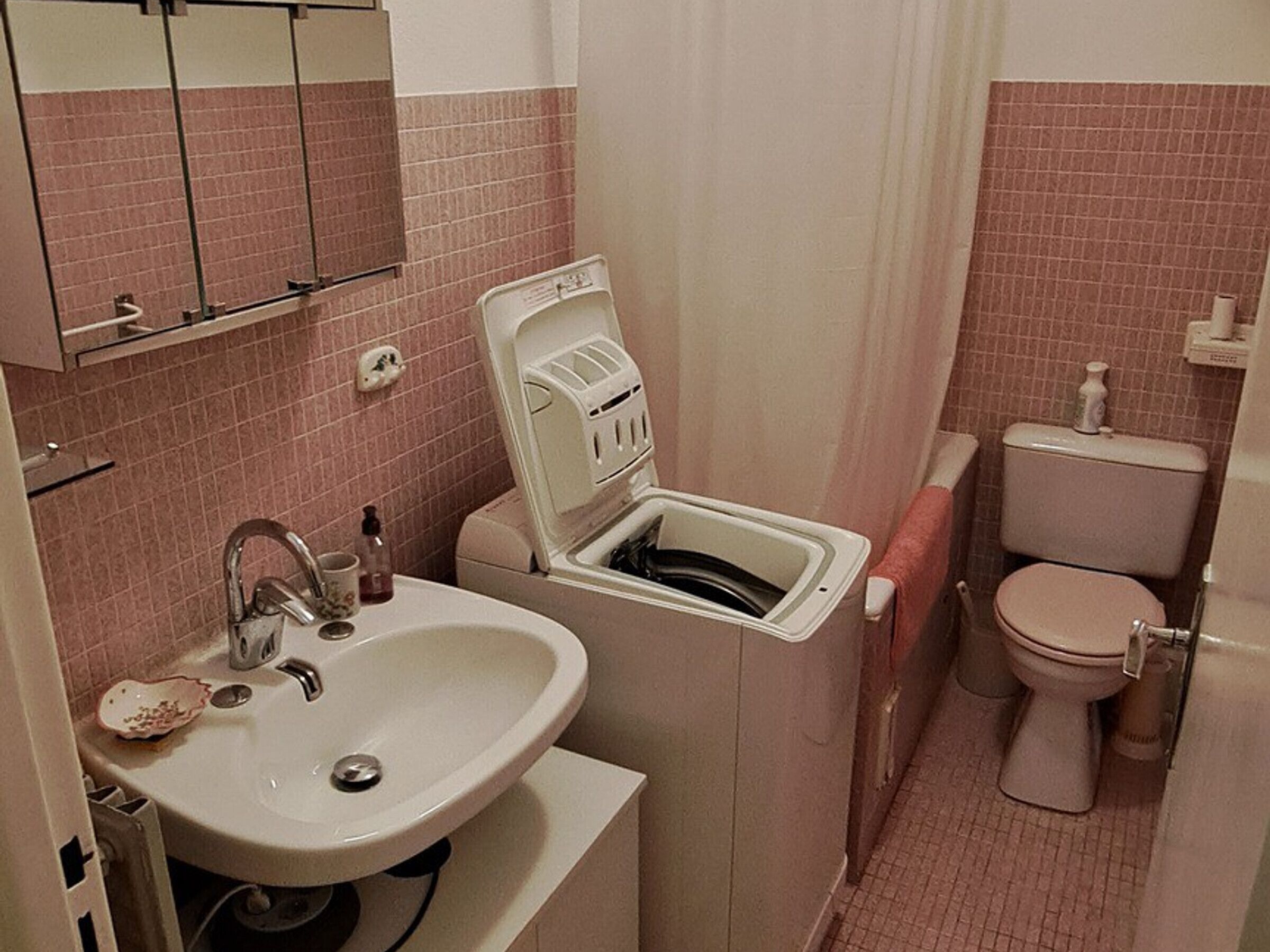 A compact bathroom with a sink, a toilet, and a shower stall.