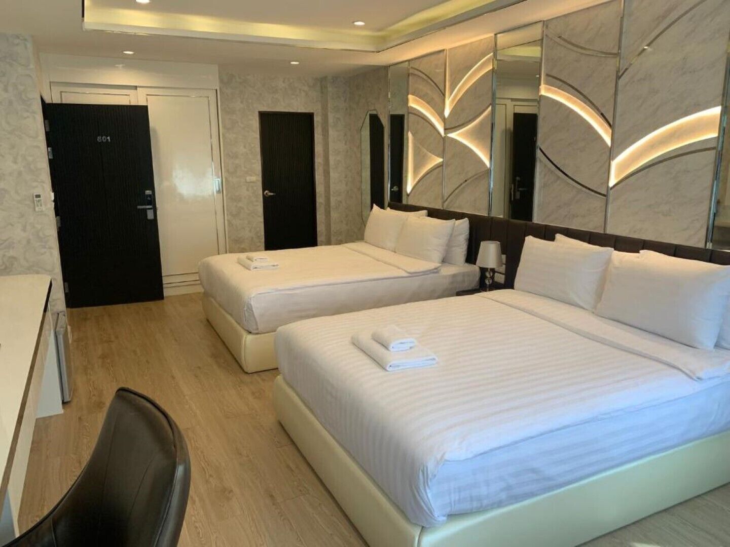 Habitación de hotel con dos camas, un escritorio y una silla.