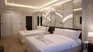 Habitació d'hotel amb dos llits, un mirall gran i un armari.