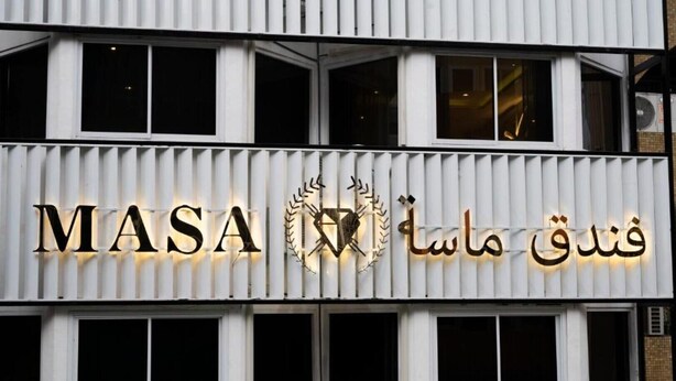 Un edifici amb un rètol que diu "MASA" i "فندل ماسا".