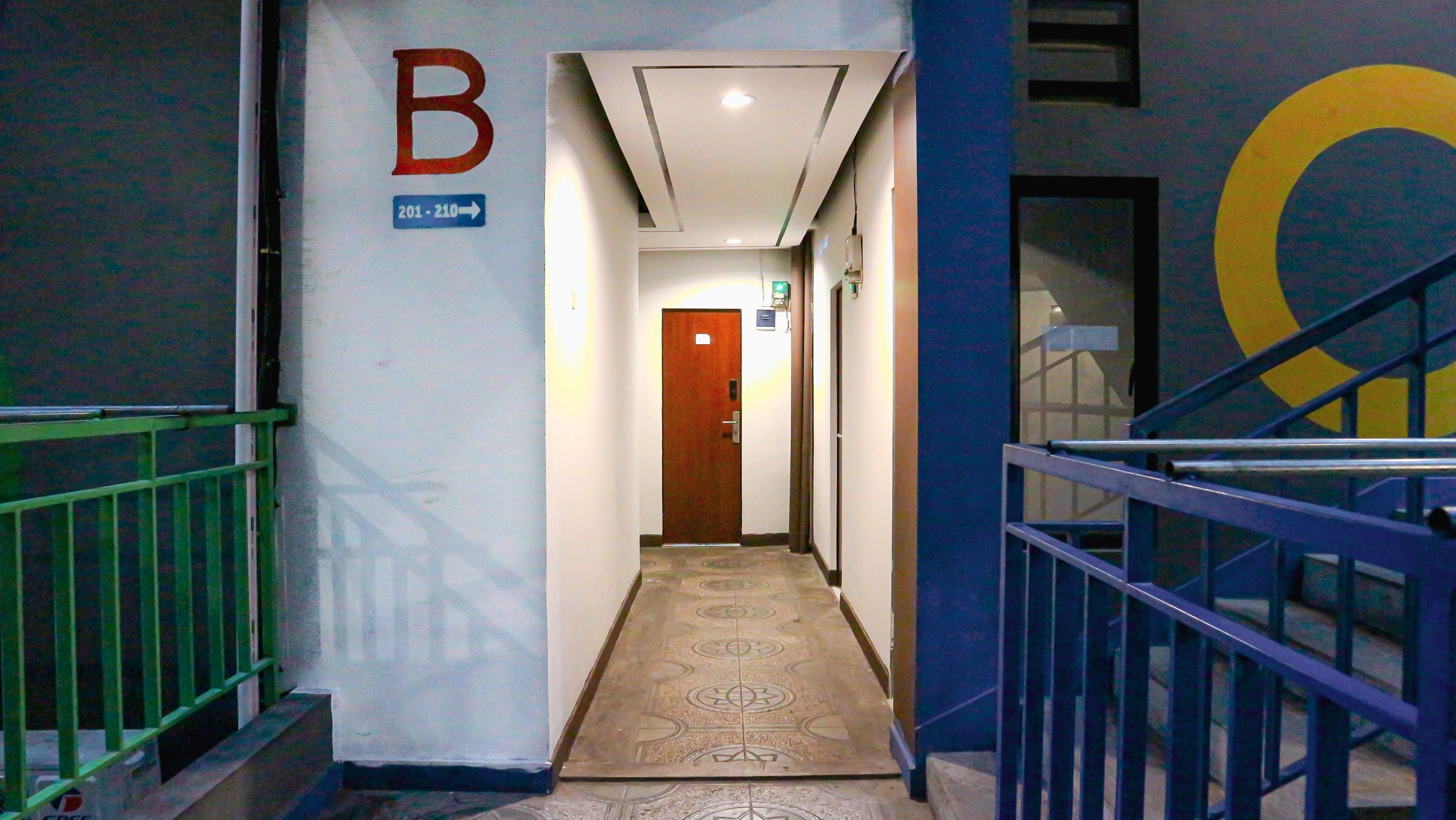 A hallway with a 'B' sign, a door, and a staircase.