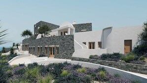Un bâtiment moderne avec une façade en pierre, des murs blancs et une allée incurvée.