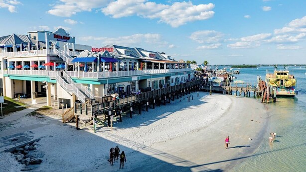 Un hôtel situé en bord de mer, doté d’une jetée qui s’avance dans l’eau, et offrant plusieurs espaces de restauration ainsi qu’un poste de surveillance pour les sauveteurs.