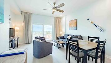 Un salon moderne avec un coin repas, un ventilateur de plafond et une vue sur la ville.