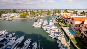Uma marina com barcos atracados, uma piscina e edifícios residenciais com varandas.