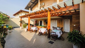 Un patio al aire libre con mesas, sillas, una mesa de billar y plantas en macetas.