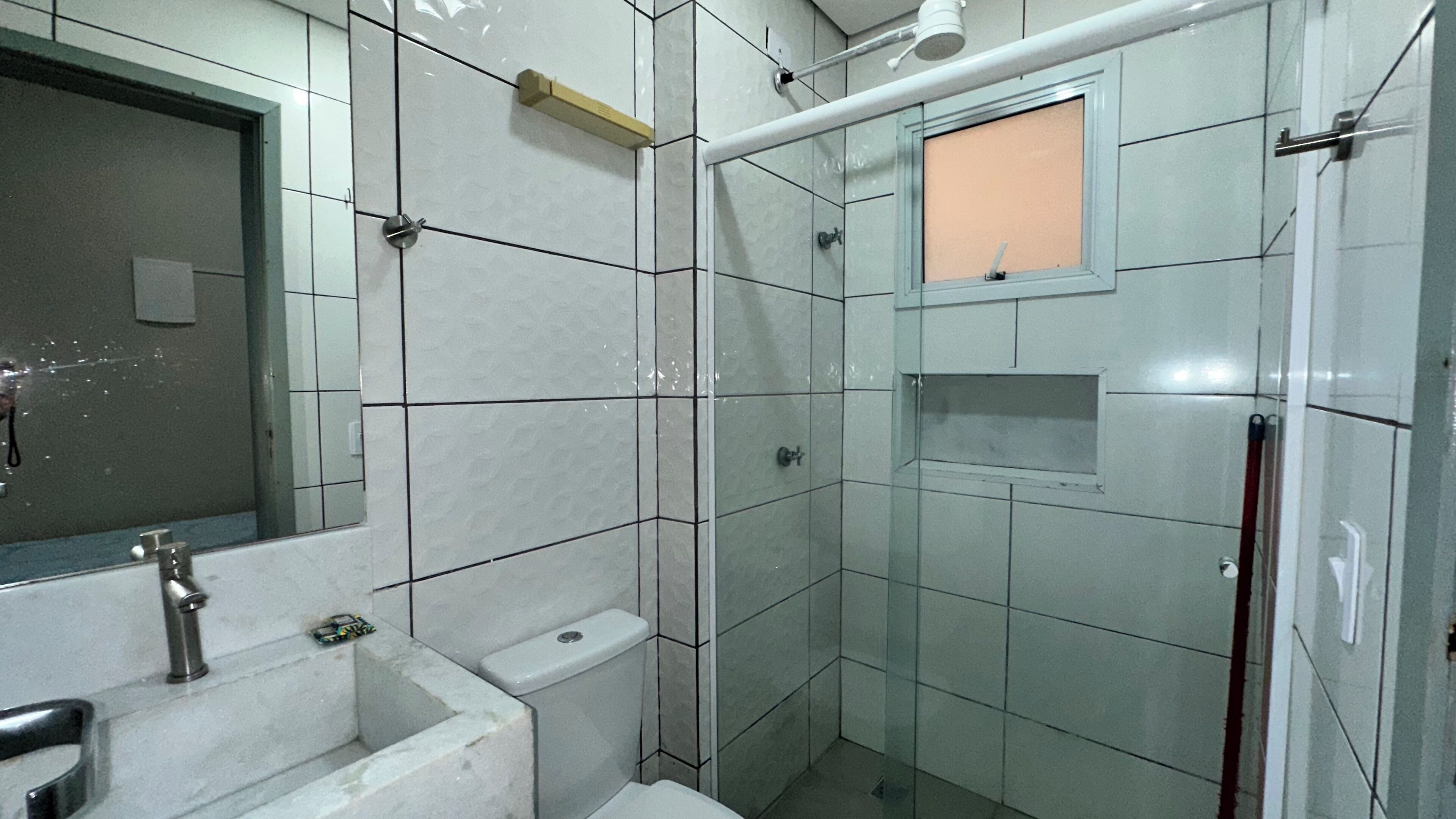 Une salle de bain comprenant un lavabo, des toilettes et un espace douche.