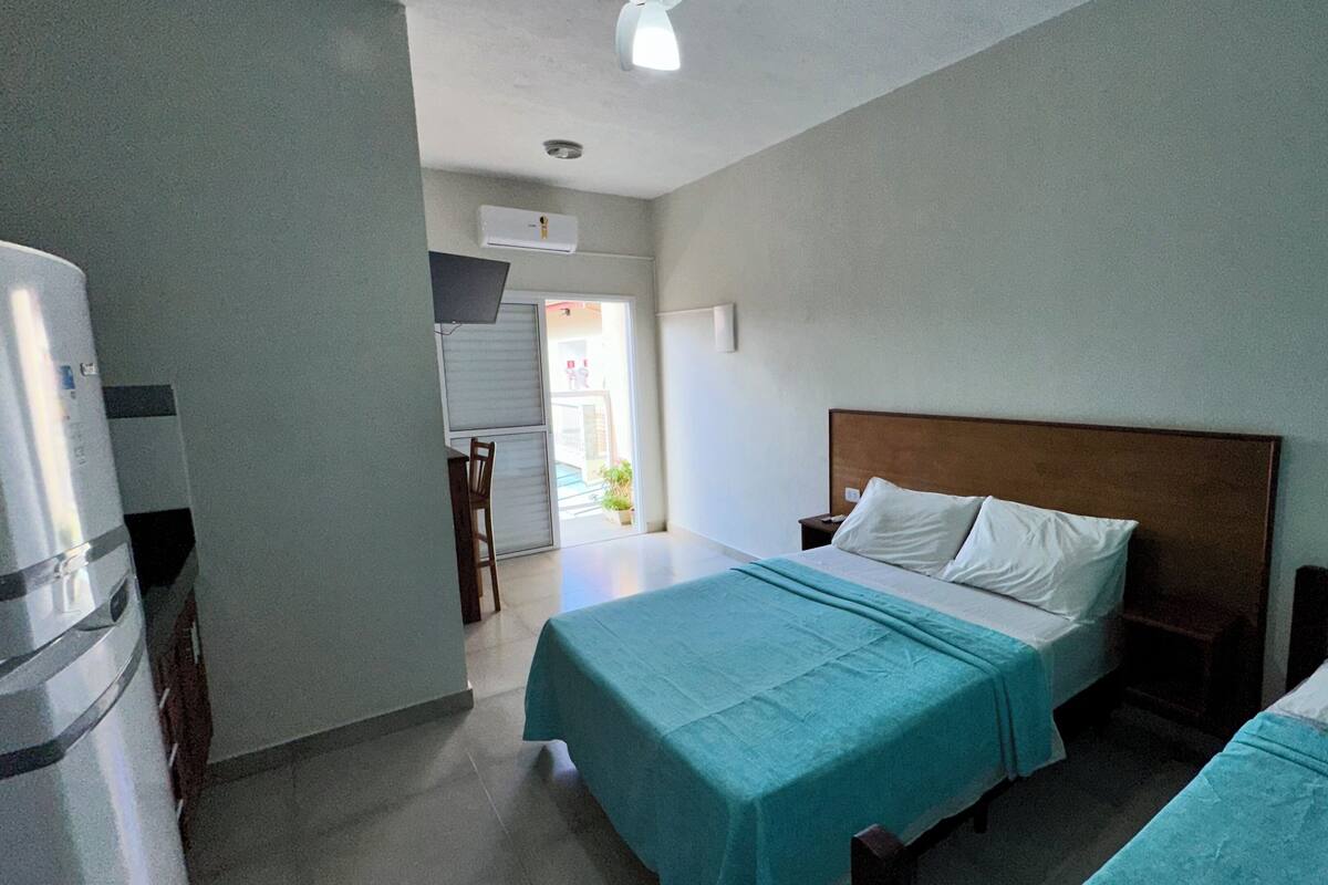 Une chambre d’hôtel avec deux lits, une kitchenette et une vue sur l’extérieur.
