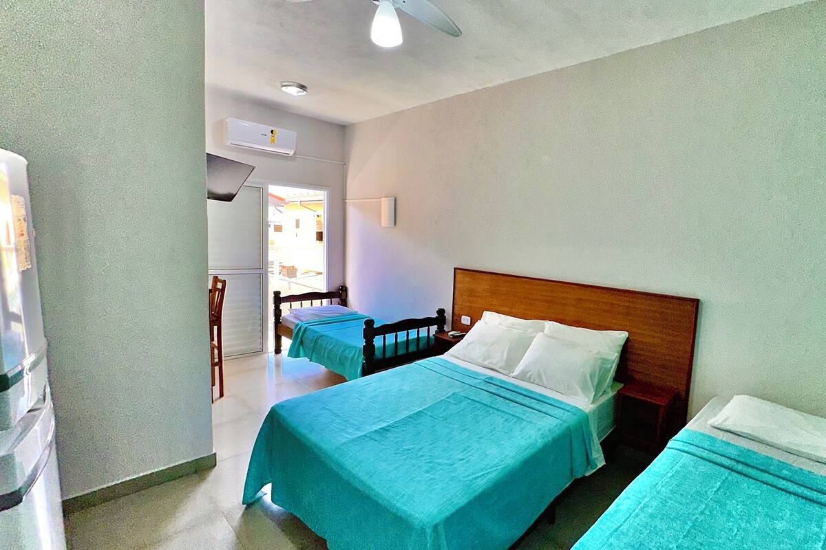 Une chambre d’hôtel avec deux lits, un ventilateur de plafond et un appareil de climatisation.