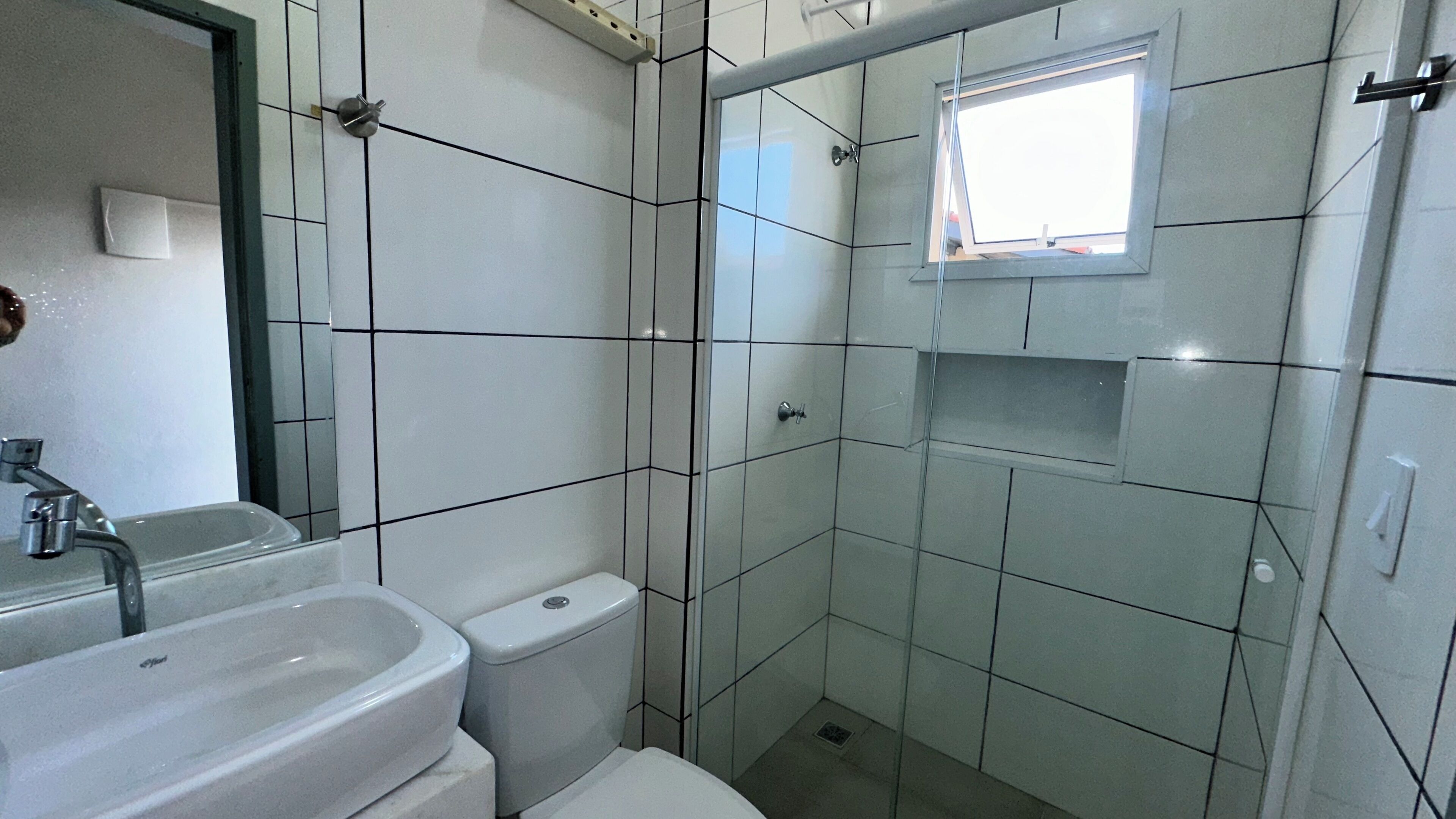 A bathroom with a sink, toilet, and shower area.