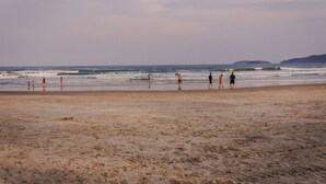 Una playa con gente caminando por la orilla.