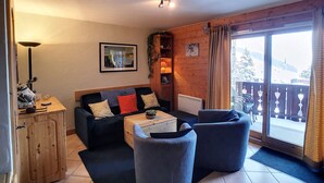 Un salon chaleureux avec un canapé, des fauteuils, une table basse et un meuble en bois.