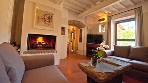 A cozy living room with a fireplace, comfortable seating, and a television.
