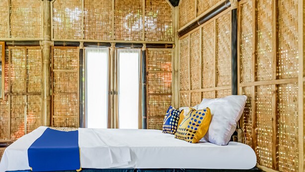 A room with a bed, a window, and a wall with a woven pattern. - Hotel O Desa Wisata Santanamekar (Cisayong)