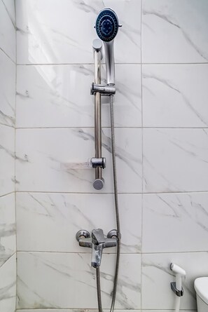 Habitación económica | Baño | Regadera, regadera tipo lluvia, toallas, papel de baño 