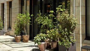 A modern building with a glass entrance canopy, potted plants, and a sign reading "The Hoxton." - The Hoxton, Berlin (Berlin)