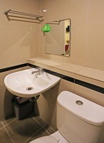 Ein Badezimmer mit einem weißen Waschbecken, einer Toilette und einem Spiegel über dem Waschbecken.