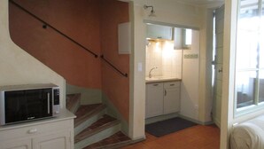 A kitchen with a microwave, sink, and cabinets. - Charming village house near Bédoin, at the foot of Mont Ventoux (Crillon-le-Brave)