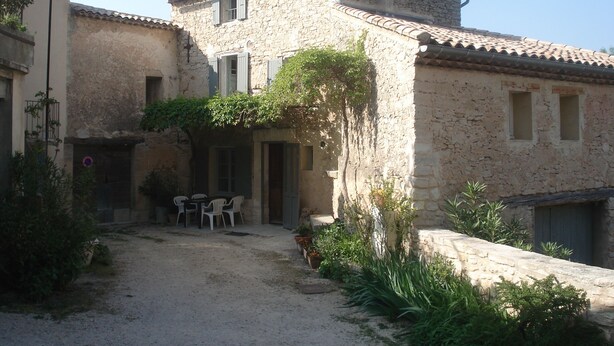 A rustic stone building with a courtyard, outdoor seating, and a gravel path. - Charming village house near Bédoin, at the foot of Mont Ventoux (Crillon-le-Brave)