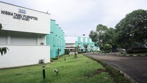 A building labeled "Wisma Tamu Puspiptek (Guest House)" with a sign indicating the number 902.